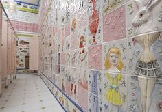 the hallway is decorated with colorful tiles and pictures on the wall, along with pink lockers