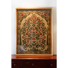 an ornately decorated wall hanging on the side of a dresser