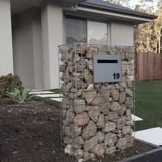 a mailbox made out of rocks in front of a house