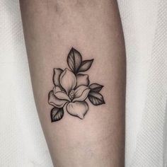 a black and white flower tattoo on the arm