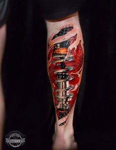 a man's leg with tattoos on it and an image of a machine in the background