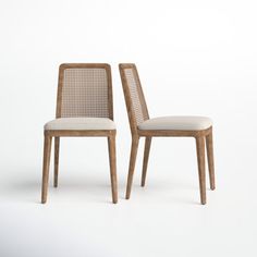 two wooden chairs sitting side by side on a white background, one has a beige upholstered seat and the other has a light colored back