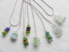 seven different colored glass beads hanging from silver chains