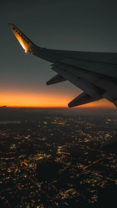 the wing of an airplane flying over a city at night