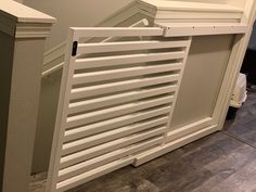 a white radiator sitting on top of a wooden floor next to a wall