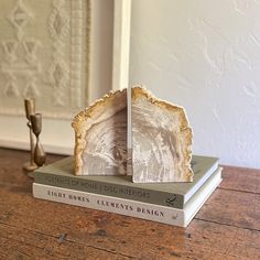 two books sitting on top of each other on a wooden table next to a figurine