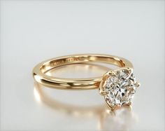 a yellow gold engagement ring with an oval cut diamond in the center, on a white background