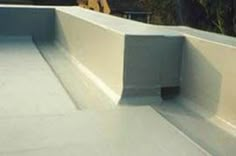 a man riding a skateboard down the side of a cement ramp at a skate park