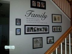 a wall with family pictures on it next to stairs