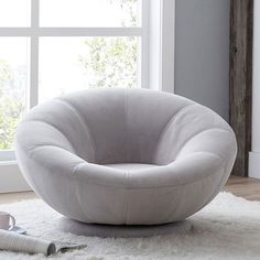 a white chair sitting on top of a shaggy rug next to a window with the words performance everyday velvet gray grooy swivel chair