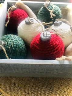 christmas ornaments in a box with twine and burlap on the tablecloth