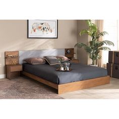 a bedroom with a bed, nightstand and plant in it