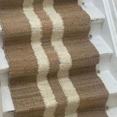 a cat is sitting on the stairs next to a carpeted stair runner that has been pulled down