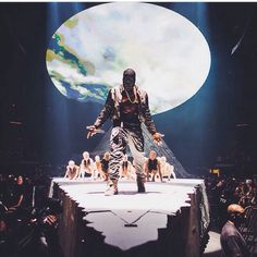 a man standing on top of a stage in front of a large group of people