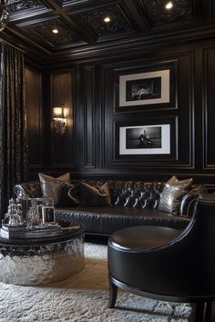 a black and white living room with leather couches, chandelier and pictures on the wall