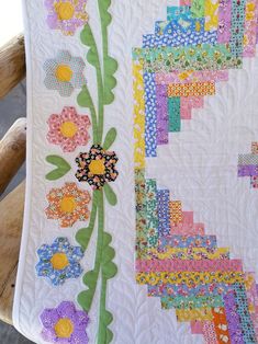 a white quilt with colorful flowers on it