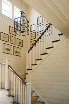 a staircase with pictures on the wall above it