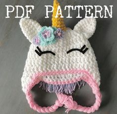 a crocheted unicorn hat with flowers on it