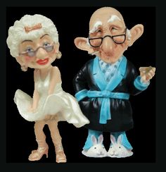 an old man and woman figurine next to each other