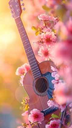 an acoustic guitar sitting in the middle of pink flowers with sunlight shining on it's back