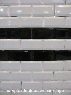 several black and white boxes stacked on top of each other in front of a wall