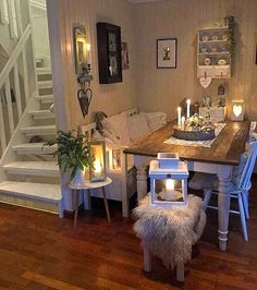 a dining room table with candles on it in front of some stairs and steps to the second floor