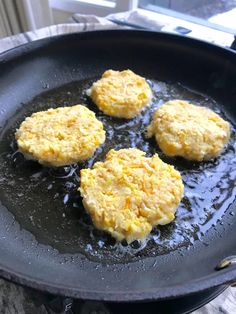 four biscuits frying in a skillet on top of a table