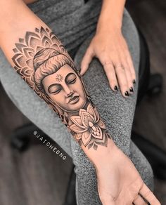 a woman's arm with a buddha tattoo on it