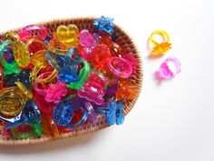 a basket filled with lots of different colored plastic rings on top of a white table