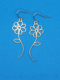 pair of earrings with flower design on blue background