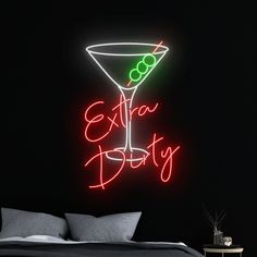 a neon sign that says extra dirty on the side of a bed in a dark room