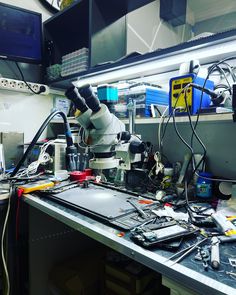 a microscope is sitting on top of a workbench with wires and other electronic equipment