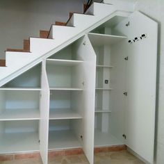 an open bookcase under the stairs in a house