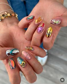 a person holding their hands with different colored nail polishes on them and gold rings around the fingers