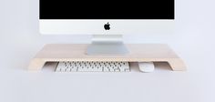 an apple desktop computer sitting on top of a wooden desk next to a keyboard and mouse