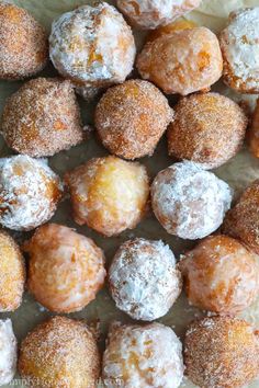 there are many different types of doughnuts on the paper bag and one is covered in powdered sugar