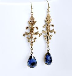 "Here is a beautiful pair of handmade earrings featuring shimmering faceted montana sapphire teardrop crystals. Styled with elegantly detailed Victorian style filigree. Earrings measure approximately 2 5/8\" long end to end (from top of ear wire to base of crystal). Drop length of 2 5/16\" long. Earrings measure 3/4\" at the widest point. These earrings are available in antique brass or antique silver color. Please select your preferred color at checkout. You will receive ONE pair of earrings. A Long Teardrop Earrings, Sapphire Earrings Drop, Prince Kaeya, Victorian Art Deco, Wedding Day Jewelry, Earrings Teardrop, Blue Accessories, Filigree Earrings, Montana Sapphire