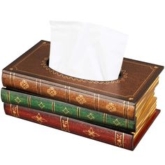 three books stacked on top of each other with a tissue dispenser