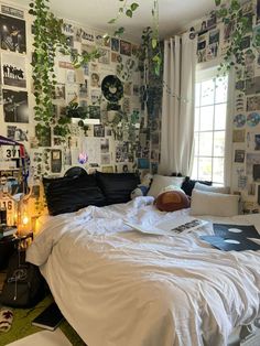 an unmade bed in a bedroom with lots of posters on the wall behind it