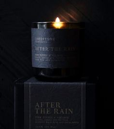 a candle sitting on top of a box with the words after the rain in it