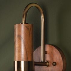 a wooden and metal wall light on a green wall