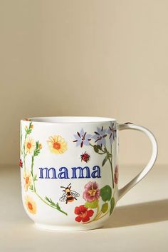 a coffee cup with the word mum printed on it and colorful flowers in the middle