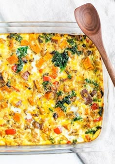 a casserole dish with vegetables and meat in it on a white tablecloth