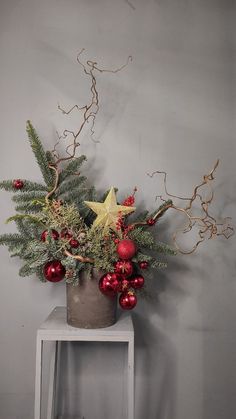 a potted plant sitting on top of a white table next to a wall with christmas decorations