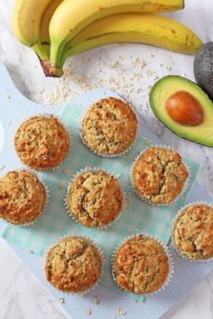 banana, avocado and apple baby muffins on a blue towel next to an avocado