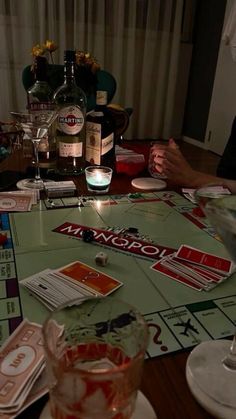 two people sitting at a table with drinks and cards on the table in front of them