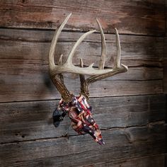 a deer's head mounted to the side of a wooden wall with an american flag scarf hanging on it