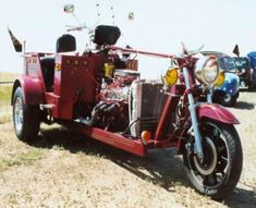 a red motorcycle with a side car attached to it's rear end in a field