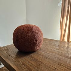 a brown round pillow sitting on top of a wooden table