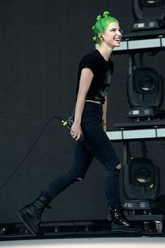 a woman with green hair walking on stage